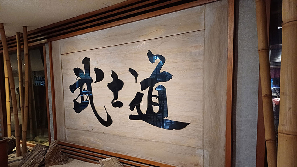 A framed calligraphy piece reading “Bushido”
